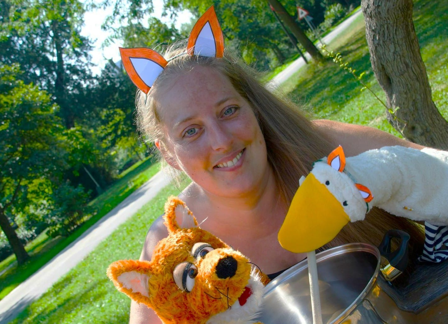 Diplompädagogin Evelyne Illetschko mit den Handpuppen Schlauer Fuchs und Gusti, die Gans, vor einem Lerntopf