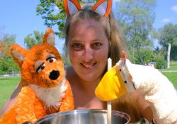 Diplompädagogin Evelyne Illetschko mit den Handpuppen Schlauer Fuchs und Gusti, die Gans, vor einem Lerntopf